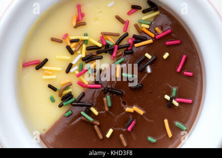 Vanille und Schokolade Creamy Dessert orned mit bunten Bonbons Stockfoto