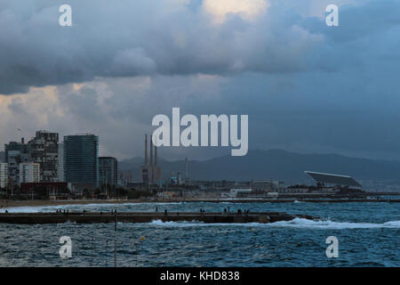 Panorama viiew von Barcelona's Wharf mit Strand und Stadt im Hintergrund in einem trüben stürmischen Nachmittag Stockfoto