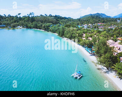 Katamaran mit Segel auf wunderschönen tropischen Strand von Koh Chang Insel verankert, Thailand Antenne Landschaft Stockfoto