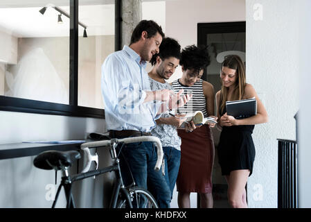 Eine Gruppe von Freunden um ständigen chatten Stockfoto
