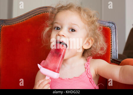 Kleine Mädchen essen Eis am Stiel Stockfoto