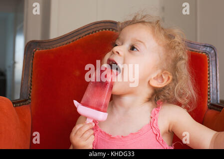 Kleine Mädchen essen Eis am Stiel Stockfoto