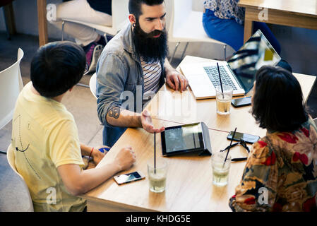 Kollegen diskutieren im Cafe Stockfoto