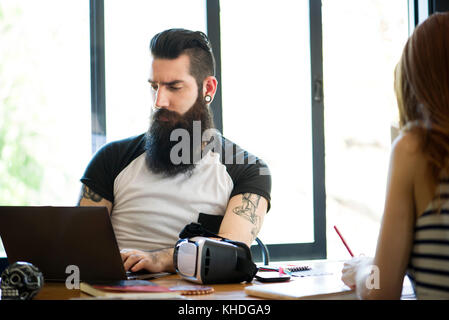 Mann bei der Arbeit am Laptop Computer in lässig-Büro Stockfoto