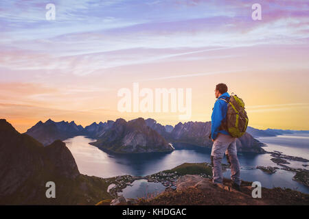 Reisen und Abenteuer Hintergrund, Wanderer mit Rucksack Landschaft Sonnenuntergang auf den Lofoten, Norwegen Stockfoto