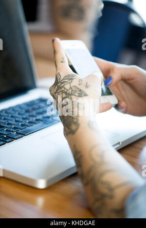 Frau Suchen bei Smartphones mit Laptop Computer, 7/8 Stockfoto