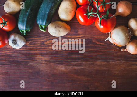 Frisches Gemüse auf hölzernen Hintergrund, Tomaten, Zwiebeln und Kartoffeln Stockfoto