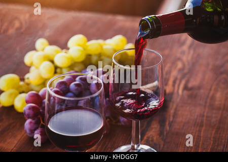 Rotwein closeup, Gießen von der Flasche zum Glas Stockfoto