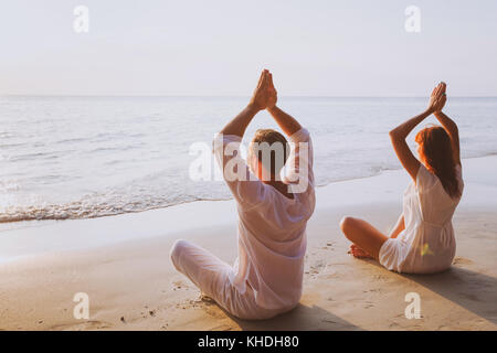 Gruppe Meditation, Yoga am Strand bei Sonnenuntergang Stockfoto