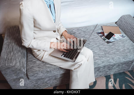 Geschäftsfrau mit Laptop im Hotel Zimmer Stockfoto