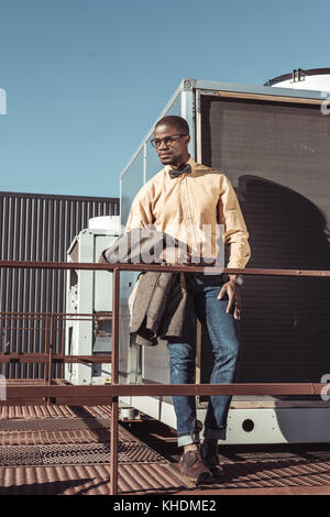Schöner Mann holding Jacke Stockfoto