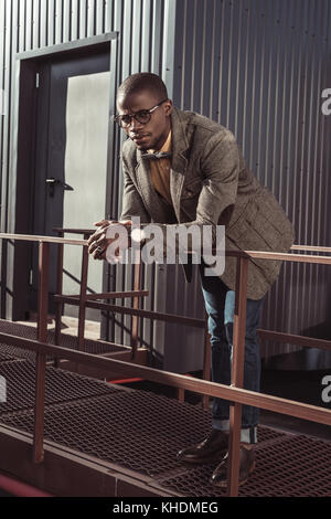 Schöne afrikanische amerikanische Mann lehnte sich auf Schutzgeländer Stockfoto