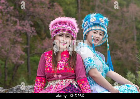 Porträt von zwei hmong Mädchen mit traditionellen Hmong Anzug auf der Sakura Blossom Hintergrund, Provinz Chiang Mai, Thailand. Stockfoto