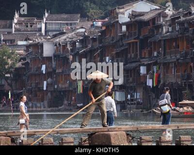 Fenghuang, China - 17 Oktober, 2016: Eine lokale Fischer in einem traditionellen Wicker hat Works auf dem River Crossing in der Altstadt von fenghuang, Hunan pro Stockfoto