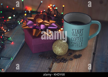 Geschenkbox und Tasse Kaffee, gold Inschrift auf dem Tisch Stockfoto