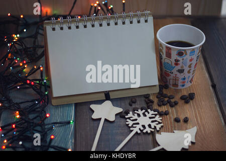 Notizblock, ein Glas mit Schneemann drucken und Dekorationen auf einer Tabelle Stockfoto