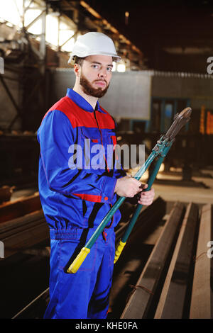 Nette Mann mit einem bolzenschneider in seinen Händen Stockfoto