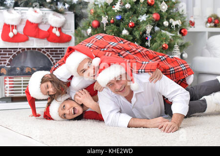 Familie in der Nähe von Christbaum posiert Stockfoto