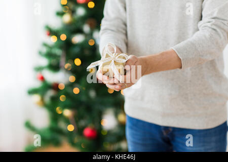 Nahaufnahme der Mann mit Geschenk zu Weihnachten zu Hause Stockfoto