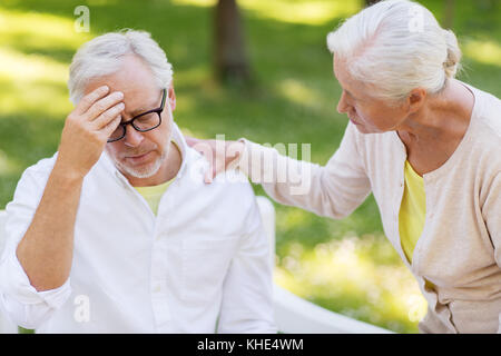 Ältere Menschen leiden unter Kopfschmerzen im Freien Stockfoto