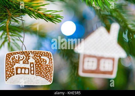 Dekorative Lebkuchen hängen an reich geschmückten Weihnachtsbaum. schöne Weihnachten Atmosphäre. kleine Schärfentiefe und Bokeh. Stockfoto