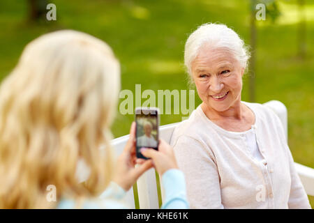 Tochter fotografieren senior Mutter von Smartphone Stockfoto