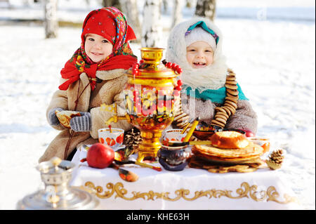 Zwei kleine Mädchen im Pelz Mänteln und Schals im russischen Stil auf seinem Stockfoto