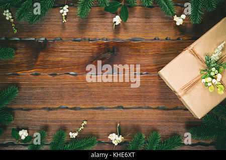 Weihnachten Geschenk, Tannenzapfen, tannenzweigen in Form von einem Frame auf Holz- braunen Hintergrund. Weihnachten Komposition. Flach, Ansicht von oben, freier Speicherplatz Stockfoto