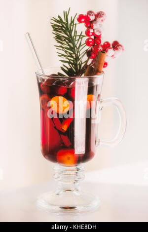 Glas duftenden Glühwein mit Beeren und Fir-Zweig auf hellen Hintergrund Stockfoto