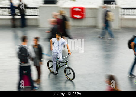 London, Großbritannien. Ein junger Teenager auf einem BMX-Fahrten durch die Massen in der Nähe von City Hall am Südufer der Themse. Stockfoto