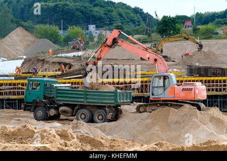 Bagger lädt die Masse im Fahrzeug Stockfoto