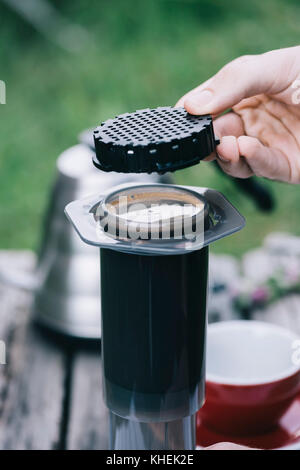 Köstliche morgen frisch gebrühten Filterkaffee im rustikalen Holztisch Hintergrund. Prozess der alternative Kaffee mit umgekehrten Methode brau Stockfoto