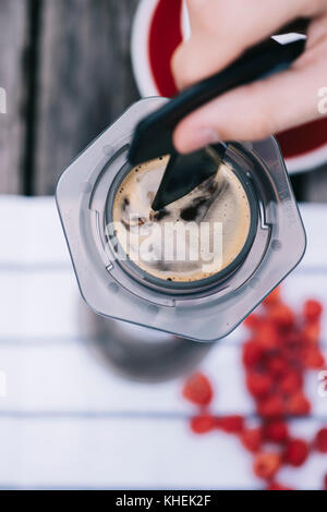 Köstliche morgen frisch gebrühten Filterkaffee im rustikalen Holztisch Hintergrund. Prozess der alternative Kaffee mit umgekehrten Methode brau Stockfoto