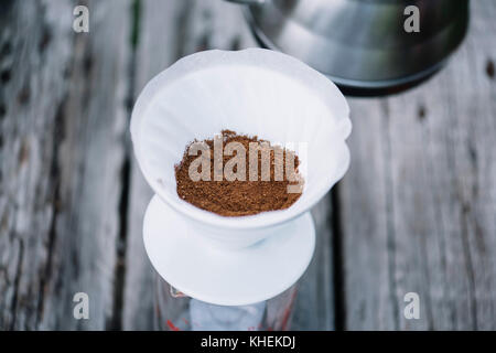 Frisch gemahlenen Kaffeebohnen im Gießen über Tropfer, etwa in köstlichen Kaffee gebrüht werden Stockfoto