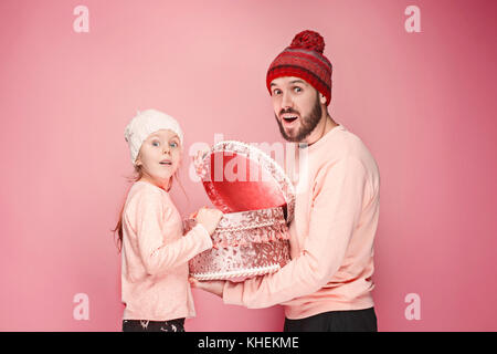 Porträt einer überrascht Kleines Mädchen mit ihrem Vater Holding ein Weihnachtsgeschenk Stockfoto