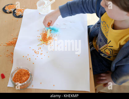 Verboten am 0001. November 17 Kinder in Tops Day Nursery in Christchurch, Bournemouth, verwenden Linsen und Reis, um Bilder zu machen, nachdem der Kindergarten verboten die Verwendung von Glitzer wegen der Bedenken über die Schäden, die es tut, um die Umwelt. Stockfoto