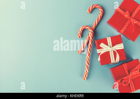 Weihnachten rot Geschenkboxen und Zuckerstangen onblue Hintergrund. Flach. Ansicht von oben. Stockfoto