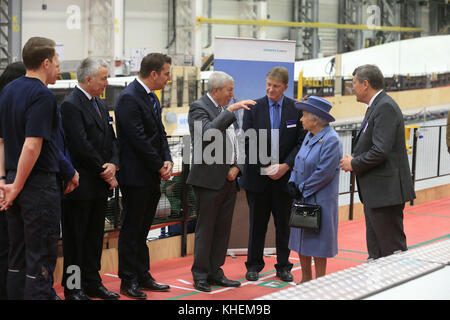 Queen Elizabeth II mit Geschäftsführer der Windkraft Division bei Siemens, Clark MacFarlane (rechts) bei einem Rundgang durch eine Rotorblattproduktionslinie bei ihrem Besuch in der Siemens Gamesa Renewable Energy Windturbine Blade Factory in Hull, Bei einem Besuch in der Stadt, um ihr Jahr als britische Kulturstadt zu markieren. Stockfoto