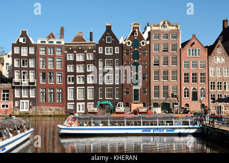 Historische Gebäude und Boot für Canal Cruise auf der Damrak, Amsterdam, Nordholland, Niederlande, Niederlande Stockfoto