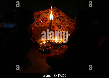 Kathmandu, Nepal. November 2017. Nepalesische Gläubige sitzen am Donnerstag, den 16. November 2017, neben einer angezündeten traditionellen Lampe zum Gedenken an ihre verstorbenen Geliebten während des Bala Chaturdashi Festivals am Ufer des Flusses Bagmati im Pashupathinath Tempel in Kathmandu, Nepal. Das Bala Chaturdashi Festival wird in Erinnerung an die Geliebten gefeiert, die glauben, dass die verstorbenen Seelen durch die Durchführung von Ritualen einen besseren Platz im Himmel sichern können. Quelle: Skanda Gautam/ZUMA Wire/Alamy Live News Stockfoto