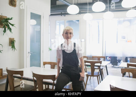 Junge Frau sitzt am Schreibtisch im Büro. Stockfoto