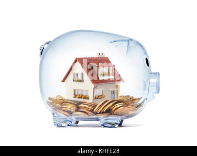 Haus auf Geld innen transparent Sparschwein mit Freistellungspfad Stockfoto