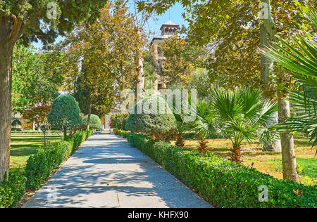 Die Gasse zwischen dem üppigen Grün der golestan Garten führt zu dem Gebäude der Sonne mit hohen Türmen, Teheran, Iran. Stockfoto