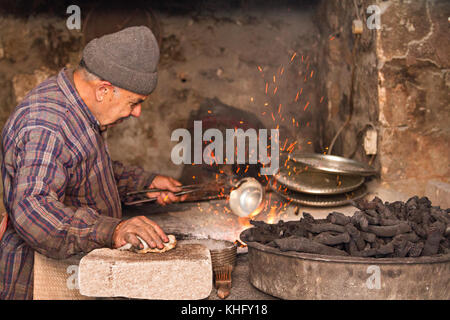 Ältere Menschen in seinem Workshop zum Thema Kupfer Schale mit Zinn in mardin, Türkei. Stockfoto