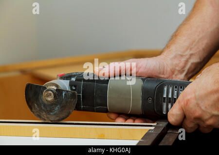 Oszillierende multi-function Power Tool auf Küchenschränke framing Hintergrund Stockfoto