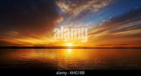 Eine markante inspirational nicht urbanen orange Cloud sunrise seascape Panorama mit bunten Meer Wasser Reflexionen. Queensland, Australien. Stockfoto