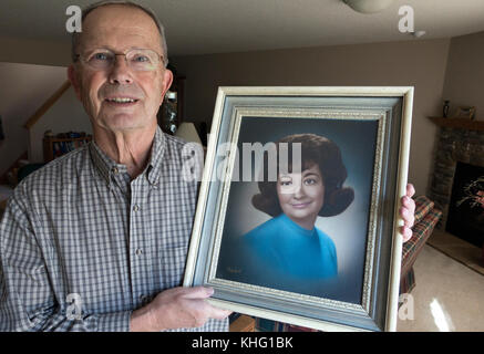 Lange Zeit Ehemann der verstorbenen Frau hält ihren High School portrait. champlin Minnesota mn Usa Stockfoto