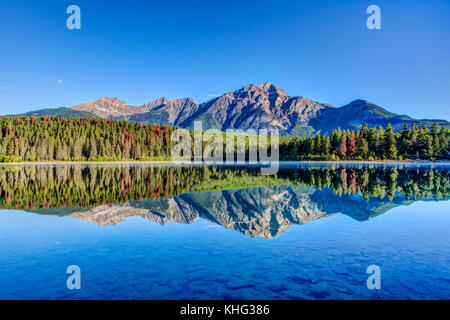 Bunten Bäumen am Ufer des Patricia Lake im Jasper National Park mit Pyramide Berg im Hintergrund. Die ruhige See spiegelt einen Spiegel imag Stockfoto