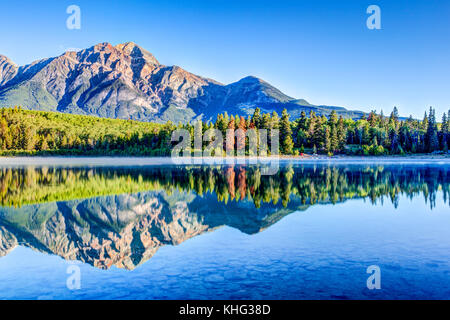 Bunten Bäumen am Ufer des Patricia Lake im Jasper National Park mit Pyramide Berg im Hintergrund. Die ruhige See spiegelt einen Spiegel imag Stockfoto