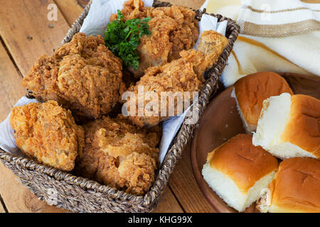 Gebratenes Huhn in einem Korb mit Abendessen Brötchen Stockfoto